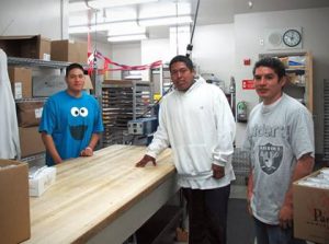 Harbor High School students George Juarez, Eric Lopez and Norberto Higaredo working in the school kitchen