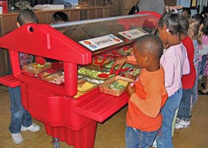 Children serving themselves from a healthy alternative salad bar at their school cafeteria