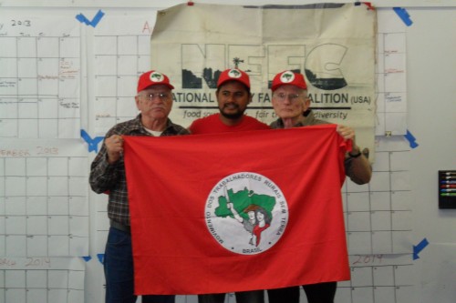 Larry, Flavio and Joe, with the flag of Brazil's Landless Worker's Movement (MST).