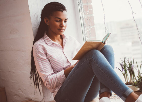 Concentrated African woman reading book