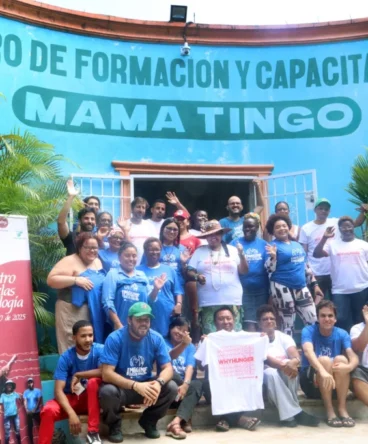Large group posing in front of Centro de Formación y Capacitación Mama Tingó