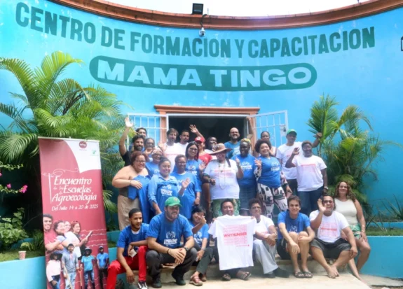 Large group posing in front of Centro de Formación y Capacitación Mama Tingó
