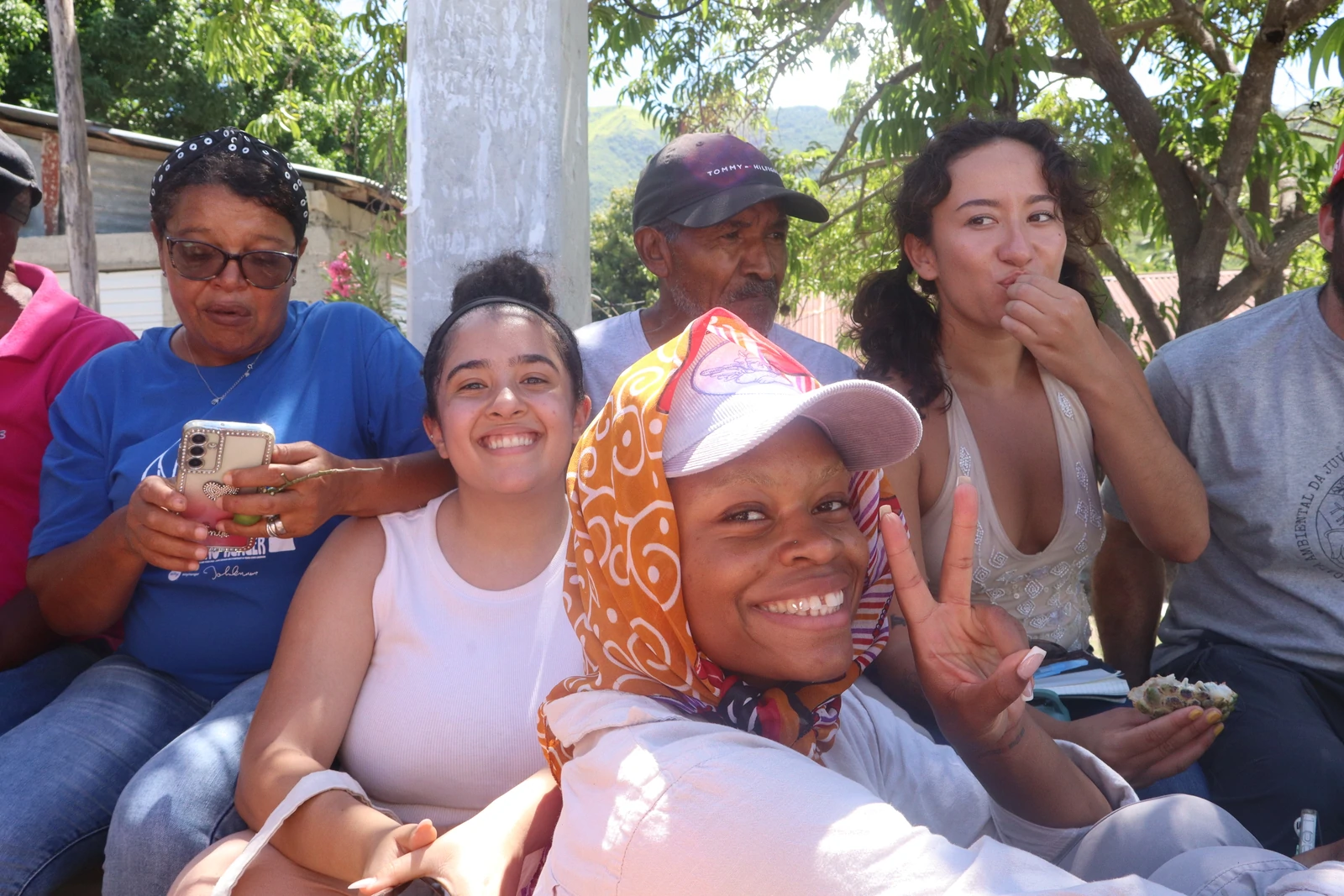 Community members gathered outdoors, smiling and sharing a moment together during a community gathering.